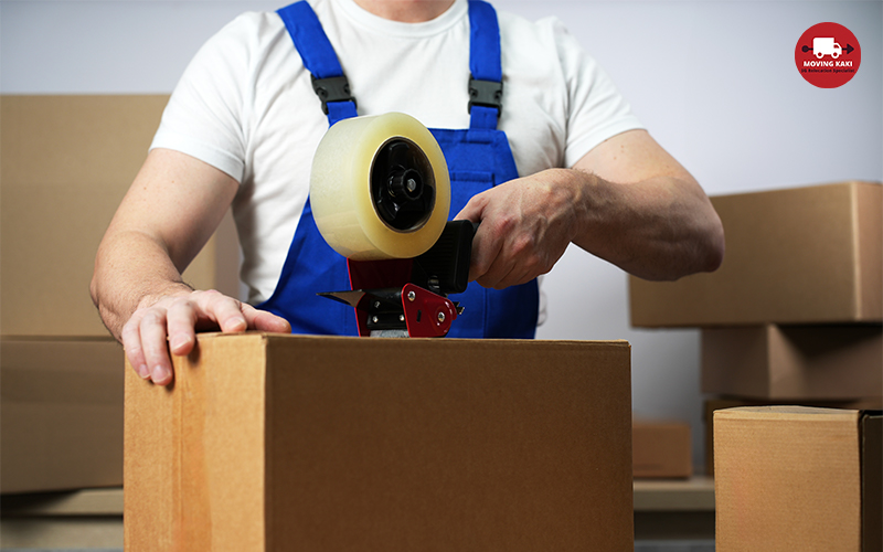 Young Worker In Uniform Holding Packing Duct Tape gun Roller Dispenser