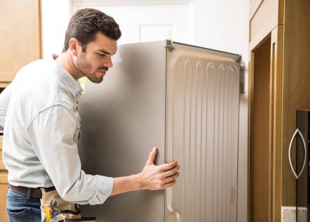 young-man-working-as-electrician-exposing-back-fridge-check-repair-it-min (1)